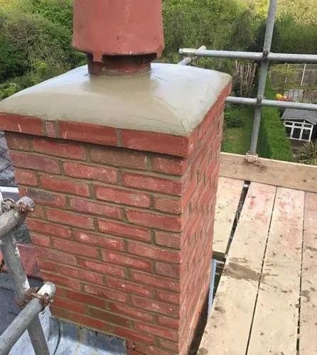 Newly capped brick chimney on scaffolding.
